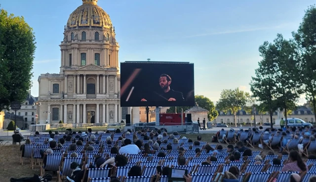 Écran LED et public installés devant le dôme des Invalides.