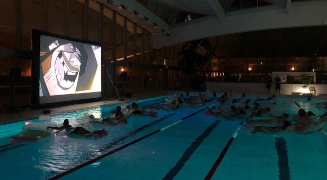Projection de cinéma au bord du bassin, face aux spectateurs sur des bouées.